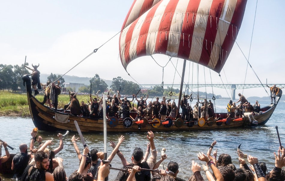 Festival Vikingo de Catoira. Imágen de desembarco vikingo. Barco entrando por el rio con guerreros y saludando