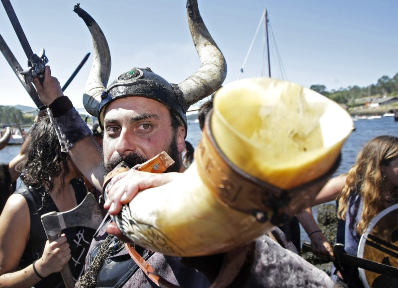 Festival Vikingo de Catoira. Imágen de desembarco vikingo Vikingo haciendo sonar su cuerno vikingo